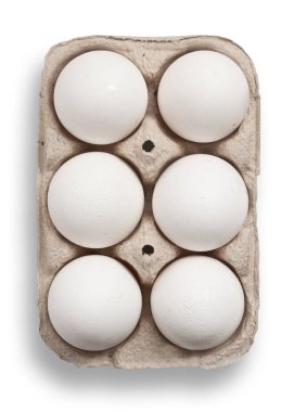 Eggs in a box on wooden table isolated, clipping path.
