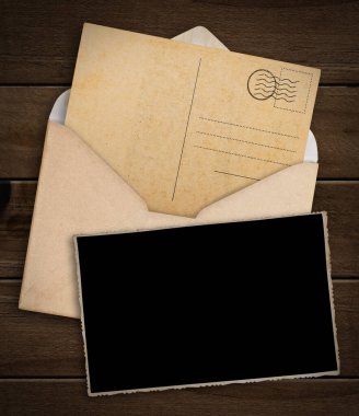 Eski kartpostal, fotoğraf ve ahşap masa üzerinde zarf.