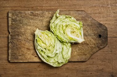 cut fresh lettuce on old wooden table.
