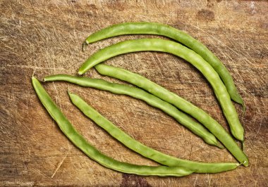 Green beans on wooden table, studio shot. 