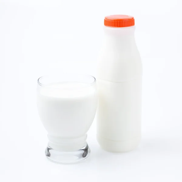 Bouteille de lait et verre sur fond blanc — Photo