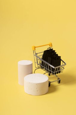 Boş taklit podyumlar, kaideler ve minyatür süpermarket arabası.