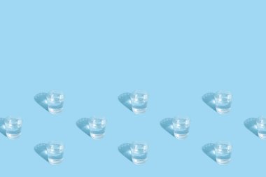 Mavi arkaplanda su ve gölge desenli bardaklar kopya alanı ile