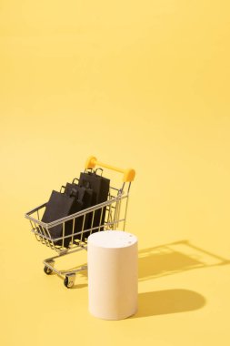 Boş sahte podyum ya da siyah alışveriş çantalı minyatür süpermarket arabası.
