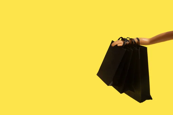 Černé Nákupní Tašky Černém Pátek Prodej Ruce Panenka Žlutém Pozadí — Stock fotografie