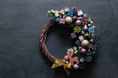 Siyah arka planda renkli dekoru olan Noel çelengi