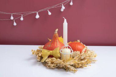 Sonbahar yaratıcı balkabakları, mumla kurumuş çiçekler.