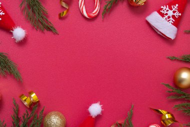 Dekoratif unsurları ve yeşil dalları olan kırmızı Noel arkaplanı kopyalama alanı ile düzleştirilmiş.