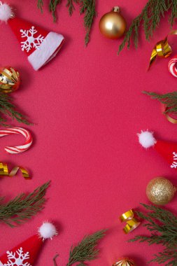 Dekoratif unsurları ve yeşil dalları olan kırmızı Noel arkaplanı kopyalama alanı ile düzleştirilmiş.