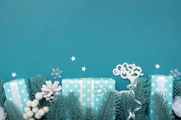 圣诞节的背景平坦，礼物、浆果和松木铺在绿松石的背景上，还有复制的空间 — 图库照片