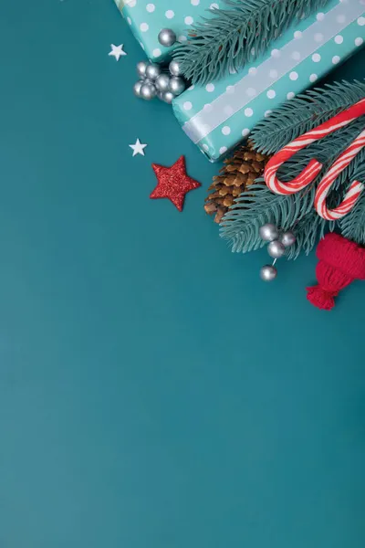 Natal plano leigos fundo com presentes, bagas e pinho em turquesa fundo vertical formato cópia espaço — Fotografia de Stock