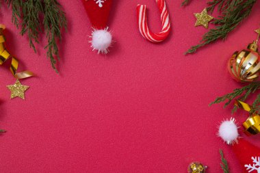 Dekoratif unsurları ve yeşil dalları olan kırmızı Noel arkaplanı kopyalama alanı ile düzleştirilmiş.