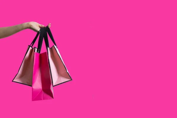 Shopping Påsar Kvinnlig Hand Isolerad Rosa Bakgrund Med Kopia Utrymme — Stockfoto