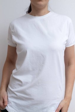 Genç bir kadın yazıtlar, reklamlar ve çizimler için beyaz tişört giyiyor..