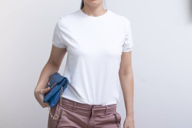 Genç bir kadın yazıtlar, reklamlar ve çizimler için beyaz tişört giyiyor..