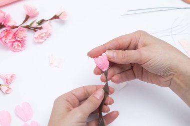 Bükülmüş kağıttan sakura çiçekleri olan bir bahar dalı oluşturuluyor. DIY Master sınıfı.