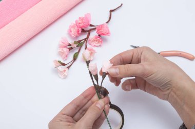 Bükülmüş kağıttan sakura çiçekleri olan bir bahar dalı oluşturuluyor. DIY Master sınıfı.