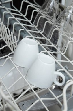 Bulaşık makinesinde beyaz bulaşıklar. Bulaşık makinesi konseptiyle ödev.