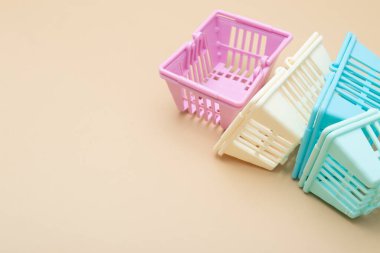 Bej arka planda renkli boş alışveriş sepetleri. Minimalizm. Satışlar, alışveriş, fiyatlar