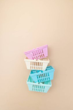 Bej arka planda renkli boş alışveriş sepetleri. Minimalizm. Satışlar, alışveriş, fiyatlar.