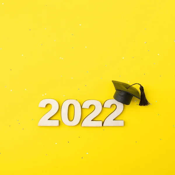 带黄色光泽背景的木制编号2022的渐进式帽子或帽子 2022级概念 — 图库照片
