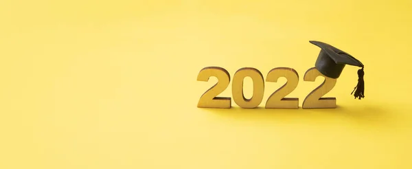带黄色光泽背景的木制编号2022的渐进式帽子或帽子 2022类横幅格式 — 图库照片