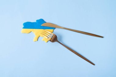 Çatal ve bıçaklı sarı ve mavi Ukrayna haritası. Ukrayna 'yla savaşta saldırganın iştahı..