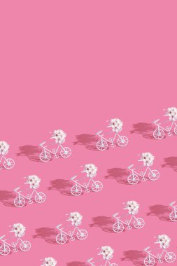 Pembe arka planda çiçekli dekoratif bisikletli patern. Kopyalama alanı olan dikey biçim.