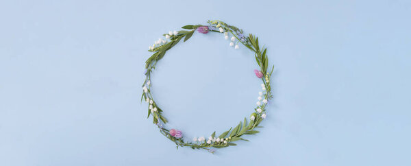 Banner with floral round frame with copy space on a blue background. Summer or spring nature minimalistic background.
