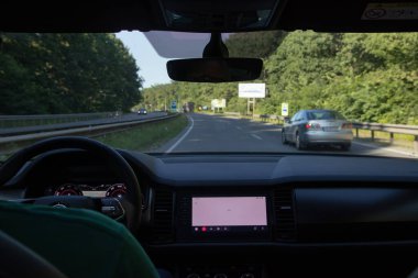 Arabanın içi yol kenarında. Direksiyon, gösterge paneli ve güverte görüntüsü.