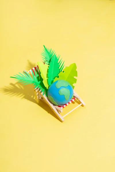 Krzesło Plażowe Planetą Liśćmi Tropikalnymi Żółtym Tle Koncepcja Minimalistycznego Ocieplenia — Zdjęcie stockowe
