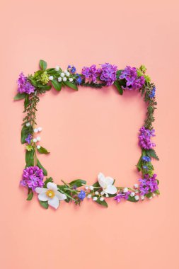 Orangır arka planda yaz ya da bahar kompozisyonu. Mor çiçekler, deniz şakayığı ve yeşil yapraklar. Yaz, bahar çiçeği konsepti.