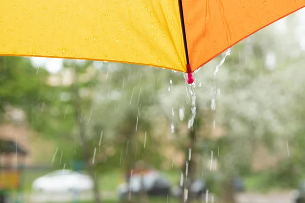 Край цветного зонта и капли дождя — стоковое фото