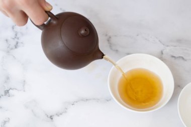Çaydanlıktan gelen çay bir fincana doldurulur. Çay töreni konsepti.