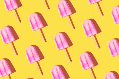 Parlak açık sarı arka planda pembe dondurmayla yapılan son moda güneş ışığı deseni. Asgari yaz konsepti.