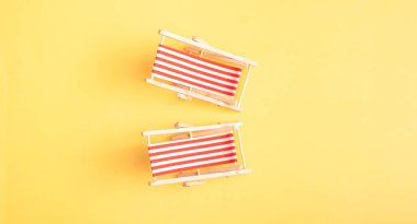 Sarı kumlu arka planda iki katlanabilir plaj sandalyesi. Yaz tatili atmosferi.