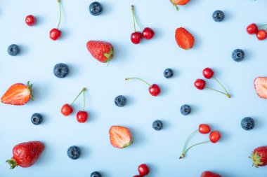 Mavi arka planda çilek, kiraz ve ahududu desenleri.
