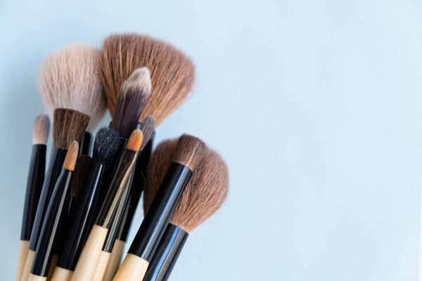 Set of makeup brushes on a blue background. Variable focus.