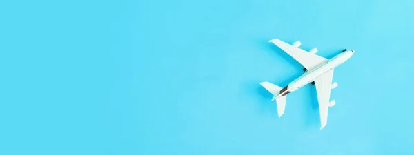 Banner with white airplane on blue background with copy space. Travel or trip concept.