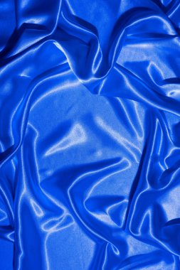 Tekstil, neon mavi-pembe ışıkta katlanır. Moda renkleri ve parlak soyut arkaplan.