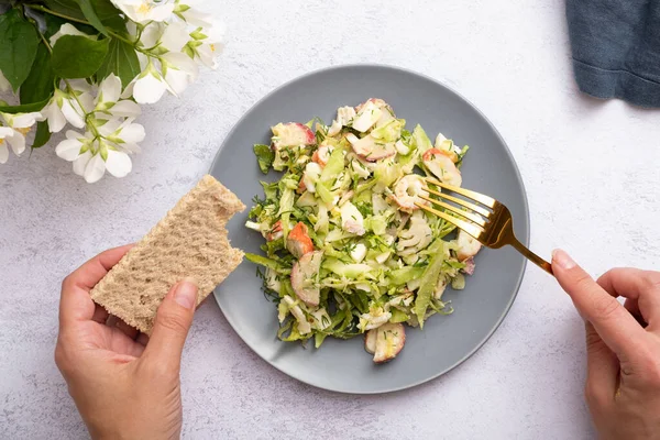 Salade Van Verse Groenten Krabbetjes Een Bord Met Vrouwelijke Handen — Stockfoto