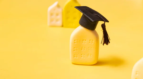 Graduate hat on the abstract building. Educational institution concept. Yellow background