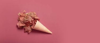 Autumn creative composition flat lay. Autumn fall leaves and vaffle cone on dark pink color background top view.