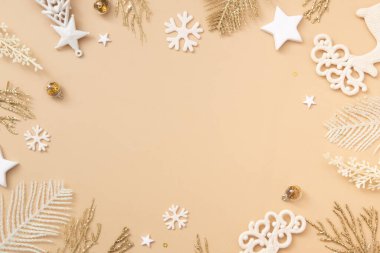 Pastel bej arka planda altın beyazı bayram süslemeleri olan Noel ve Yeni Yıl kutlamaları. Üst Manzara. Mutlu Noeller tek renkli konsepti.
