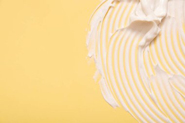 Renkli arkaplanda fotokopi alanı yatay formatında yakın plan krem nemlendirici lekeli dalga dokusu. Cilt bakımı güzellik ürünü.