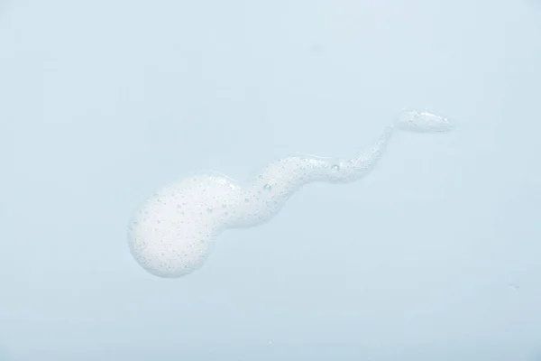 面部清洁慕斯样品 蓝色背景上的白色清洁剂泡沫泡沫 淋浴露 洗发水泡沫质感特写 — 图库照片
