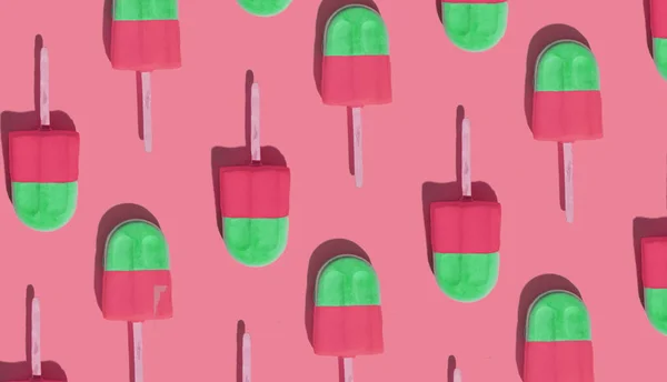 Two colored ice creams on a stick on a colored background. Creative pattern. Hot summer weather concept. Refreshing summer food.