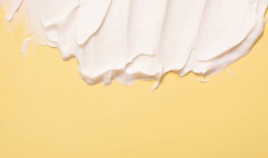 Renkli arkaplanda fotokopi alanı yatay formatında yakın plan krem nemlendirici lekeli dalga dokusu. Cilt bakımı güzellik ürünü.