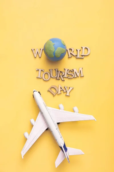 World Tourism Day Text Wooden Letters Globe Airplane Yellow Background — 스톡 사진