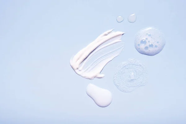 Renkli arkaplanlı serum ve nemlendirici makyaj kremi. Üst görünüm.